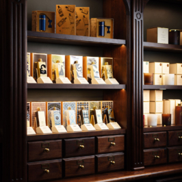 A lavish, ornately designed boutique room with elegant floral wallpaper, gilded frame wall art, and intricate gold detailing, creating a luxurious Parisian ambiance.