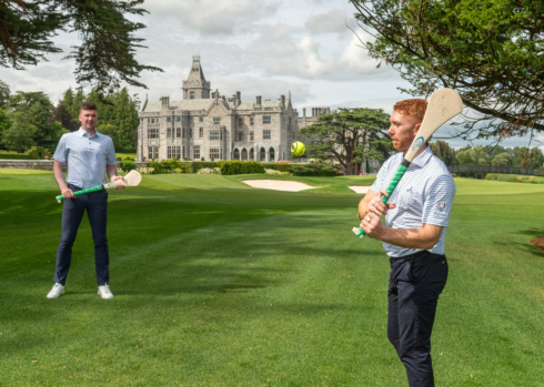 A grand and historic manor house with lush green lawns, manicured gardens, and a partially cloudy sky, creating an elegant and timeless atmosphere.